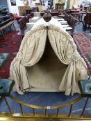 A VERY GRAND DOG BED HUNG WITH DRAPERY AND HAVING CARVED FINIALS. H.119cms. W.117cms. D.78cms.