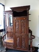 A LARGE AND IMPRESSIVE LATE VICTORIAN CARVED OAK HALL STAND WITH BOX SEAT, PANELLED DOOR CUPBOARD