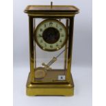 A LATE VICTORIAN GILT BRASS FOUR GLASS MANTLE CLOCK WITH ENAMELLED CHAPTER RING AND ENGRAVED CENTRE,