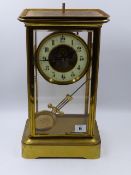 A LATE VICTORIAN GILT BRASS FOUR GLASS MANTLE CLOCK WITH ENAMELLED CHAPTER RING AND ENGRAVED CENTRE,