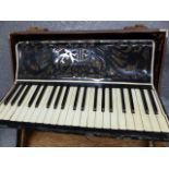 A VINTAGE UNSIGNED PIANO ACCORDIAN IN A PROTECTIVE CASE TOGETHER WITH AN H.M.V. PORTABLE