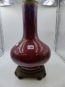 A CHINESE SANG DE BOEUF GLAZE LARGE BOTLE FORM VASE MOUNTED AS A LAMP ON CARVED HARDWOOD BASE.