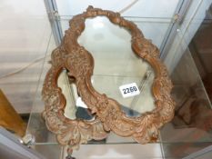 A PAIR OF CONTINENTAL SMALL CARVED MIRRORS OF SHAPED FORM IN THE ROCOCO TASTE. H.36cms.