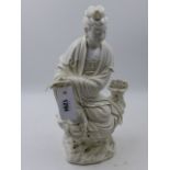 A CHINESE BLANC DE CHINE FIGURE OF A DEITY SEATED ON A ROCK WORK BASE HOLDING A SCROLL. H.38cms.