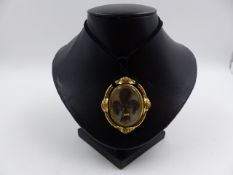 AN EARLY VICTORIAN REVERSIBLE MOURNING PENDANT. ONE SIDE FEATURES INTRICATELY WOVEN HAIR ACCENTED