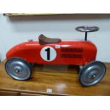 A VINTAGE CHILD'S TIN PLATE SIT ON MODEL RACING CAR.