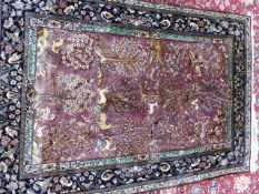 AN ORIENTAL PART SILK RUG OF PERSIAN ANIMAL DESIGN WITH CALLIGRAPHIC BORDER PANELS. 185 x 130cms.