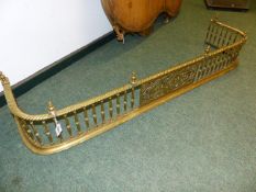 A VICTORIAN POLISHED BRASS 'D' FORM FIRE FENDER, TURNED SUPPORTS AND FINIALS. CENTRAL PIERCED TABLET
