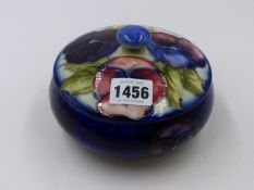 A MOORCROFT POTTERY LIDDED BOWL DECORATED WITH PANSIES. Dia.15cms.