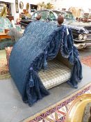 A VERY GRAND DOG BED HUNG WITH DRAPERY AND HAVING CARVED FINIALS. H.120cms. W.117cms. D.82cms.