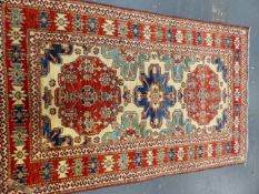 AN ORIENTAL RUG OF CAUCASIAN DESIGN. 202 x 127cms.