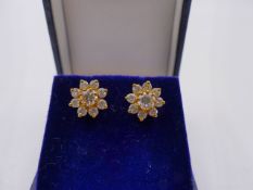 A PAIR OF YELLOW METAL DIAMOND CLUSTER CLAW SET STUD EARRINGS. APPROXIMATE TOTAL ESTIMATED DIAMOND