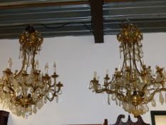 AN IMPRESSIVE PAIR OF GILT BRASS CAGE CHANDELIERS HUNG WITH LARGE CUT GLASS AND FACET DROPS. H.