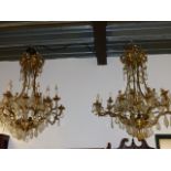 AN IMPRESSIVE PAIR OF GILT BRASS CAGE CHANDELIERS HUNG WITH LARGE CUT GLASS AND FACET DROPS. H.