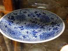 TWO CHINESE BLUE AND WHITE SAUCER DISHES EACH DECORATED WITH FLOWER HEADS AND SCROLLING FOLIATE