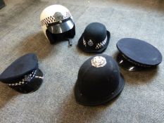 A POLICE MOTORCYCLE HELMET AND FOUR OTHER POLICE HATS.