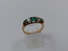 A VICTORIAN 9ct YELLOW GOLD EMERALD AND DIAMOND FIVE STONE HALF HOOP RING. THE GRADUATED STONES
