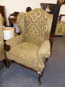 A PAIR OF CARVED WALNUT EARLY GEORGIAN STYLE HIGH BACK WING ARMCHAIRS WITH GILT DETAILS.