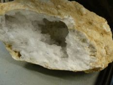 A LARGE GEODE SPECIMEN WITH EXPOSED CRYSTAL INTERIOR AND VARIOUS FOSSILS.