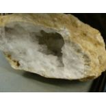 A LARGE GEODE SPECIMEN WITH EXPOSED CRYSTAL INTERIOR AND VARIOUS FOSSILS.