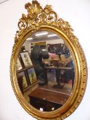 A 19th.C.FRENCH GILT OVAL MIRROR WITH PIERCED FLORAL AND SCROLL FORM CREST SURMOUNTED BY A SHELL.