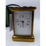 A SWISS MADE BRASS CASED CARRIAGE CLOCK WITH WHITE ENAMEL DIAL, THE SIDES WITH PICTORIAL PANELS