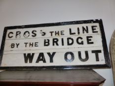 A VINTAGE RAILWAY CROSS THE LINE BY THE BRIDGE SIGN.