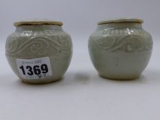 A NEAR PAIR OF EARLY CHINESE CELADON COVERED JARLETS EACH DECORATED WITH SCROLLING BANDS. H.6.5cms.