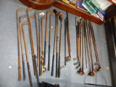 A COLLECTION OF VINTAGE WOOD SHAFTED GOLF CLUBS AND A MODERN GOLFING DISPLAY.