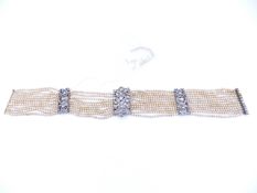 A MULTI STRAND EDWARDIAN PEARL AND ORNATE PASTE CHOKER, STAMPED 900. APPROXIMATE LENGTH 33.5cms.