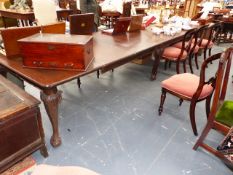 A MAHOGANY EXTENDING DINING TABLE IN THE GEORGIAN TASTE WITH SIX CARVED LEGS WHICH END IN BALL AND