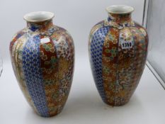 A PAIR OF JAPANESE IMARI BALUSTER FORM VASES, EACH WITH VERTICAL BANDS OF GEOMETRIC AND FOLIATE