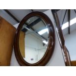 A LARGE OVAL WALL MIRROR.