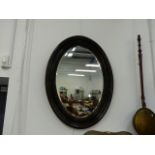 A LARGE OVAL WALL MIRROR.