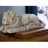 A LARGE CAST SCULPTURE OF A RECUMBENT LION.