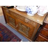 AN ANTIQUE CARVED OAK SMALL SIDE CABINET.
