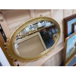 A MODERN GILT FRAMED OVAL MIRROR.