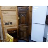 A CARVED OAK TWO PART FLOOR STANDING CORNER CABINET.