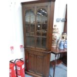 AN OAK CORNER CABINET.