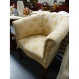 A LARGE TUB CHAIR ON CABRIOLE LEGS.