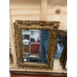 A GILT FRAMED MIRROR.