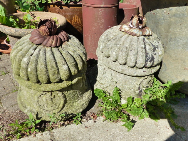 A PAIR OF ANTIQUE CARVED STONE FINIALS WITH IRON LEAF KNOPS.