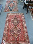 AN ANTIQUE PERSIAN HAMADAN RUG. 129 x 75cms TOGETHER WITH A SHIRAZ RUG OF SIMILAR SIZE. (2).`