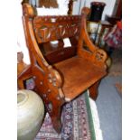 A LATE VICTORIAN GOTHIC REVIVAL OAK HALL SEAT WITH CARVED PIERCED BACK.