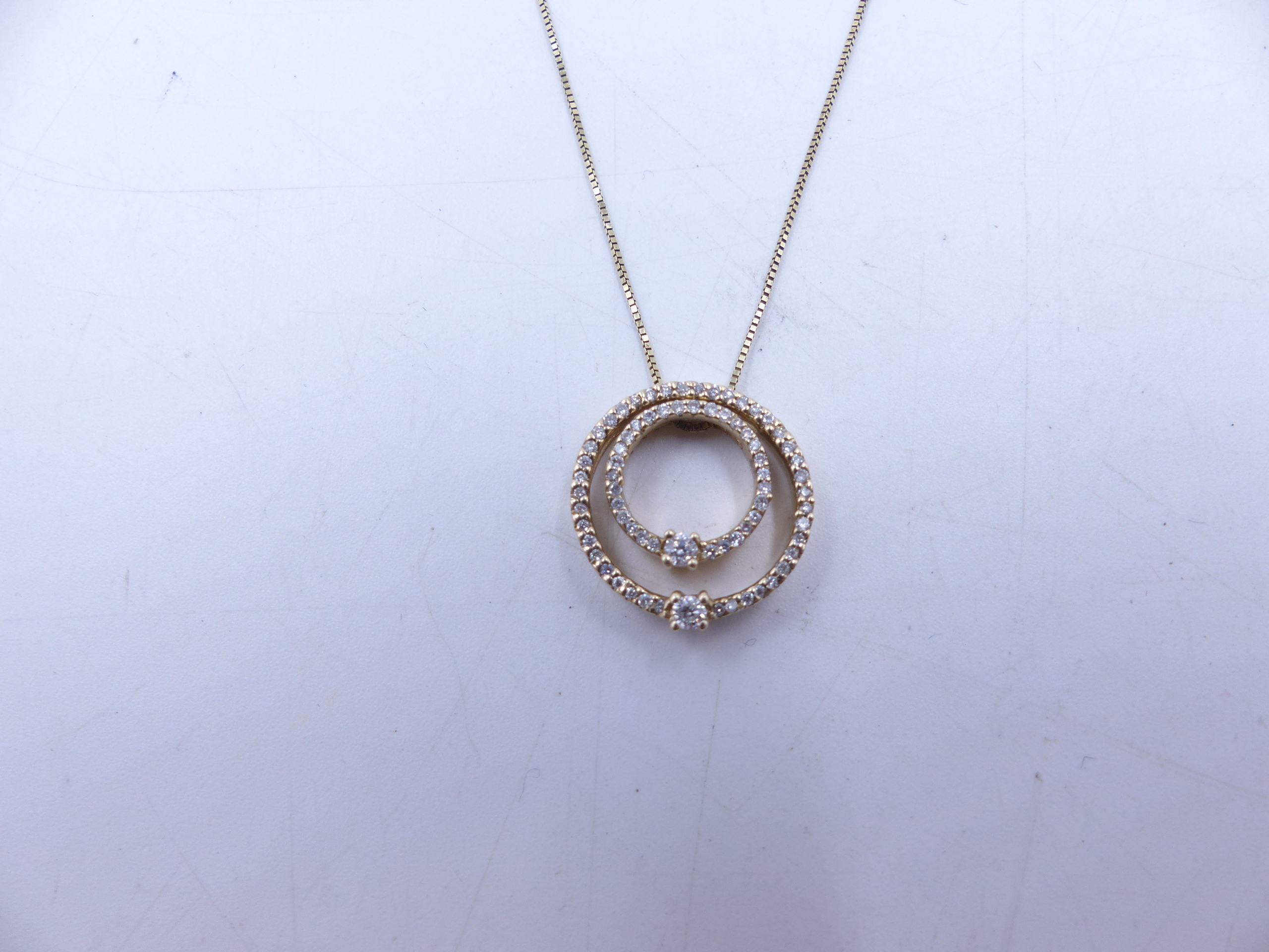A 9ct YELLOW GOLD DOUBLE DIAMOND HALO PENDANT. TWO HALOS OF DIAMONDS ARE NESTED TOGETHER AND