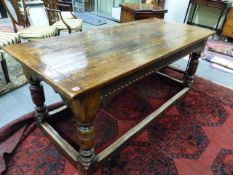 A GOOD 17th.C.STYLE OAK REFECTORY TABLE WITH CARVED FRIEZE AND STRETCHER BASE, THE TOP 184 x 81 x