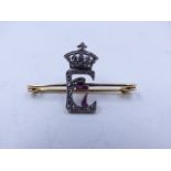 A DIAMOND AND RUBY SET YELLOW METAL PIN, FORMED IN THE LETTER E ENTWINED WITH A NUMBER 7, A GIFT FOR