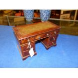 AN ANTIQUE MINIATURE MAHOGANY AND WALNUT PEDESTAL DESK FORM JEWELLERY BOX WITH RISING TOP OVER