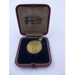 A CASED 18ct STAMPED REVERSE BOWDON GOLF CLUB MEDALLION WITH THE SLOGAN GOLD IS NOT AGRICULTURE