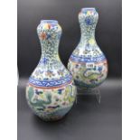 A PAIR OF ORIENTAL GARLIC NECK VASES DECORATED WITH DRAGONS AND BANDS OF SCROLLING FOLIAGE. H.